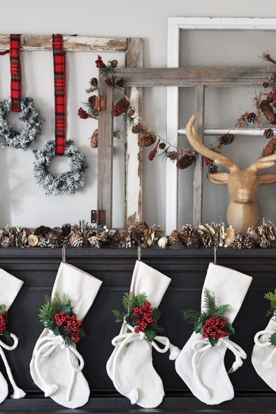 Super Cozy Christmas Mantel with drop cloth stockings, mini wreaths, pine cones, and a deer head!