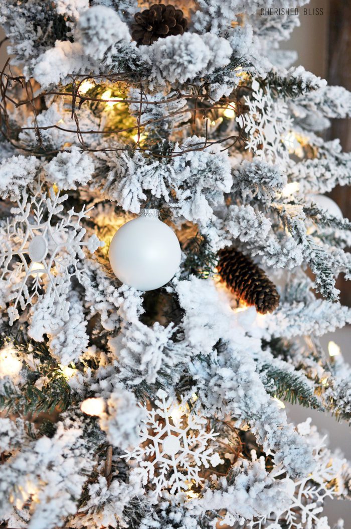 A simple White Flocked Christmas tree with white ornaments and a few rustic touches