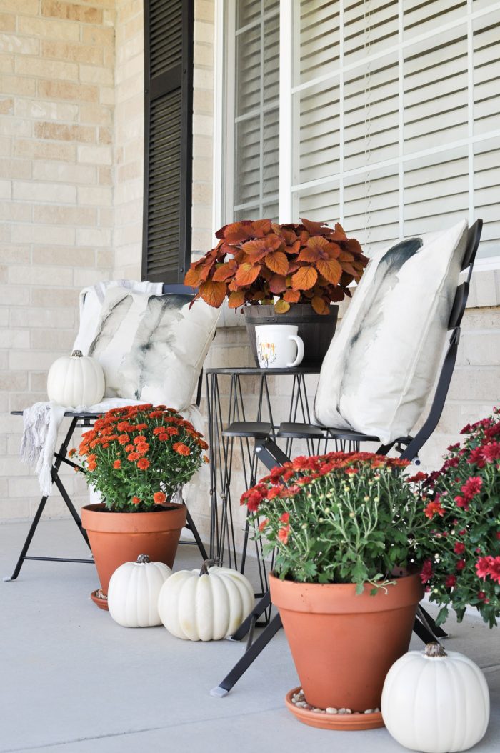 Create a Simple Fall Porch with a few flowers and white pumpkins. The perfect way to enjoy the season!