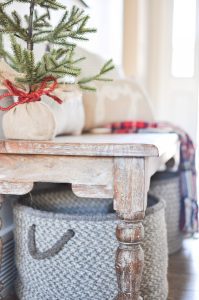 Take a tour through a simple farmhouse style Christmas Entryway. A basic bench, throw pillows, and a blanket create this cozy entrance!