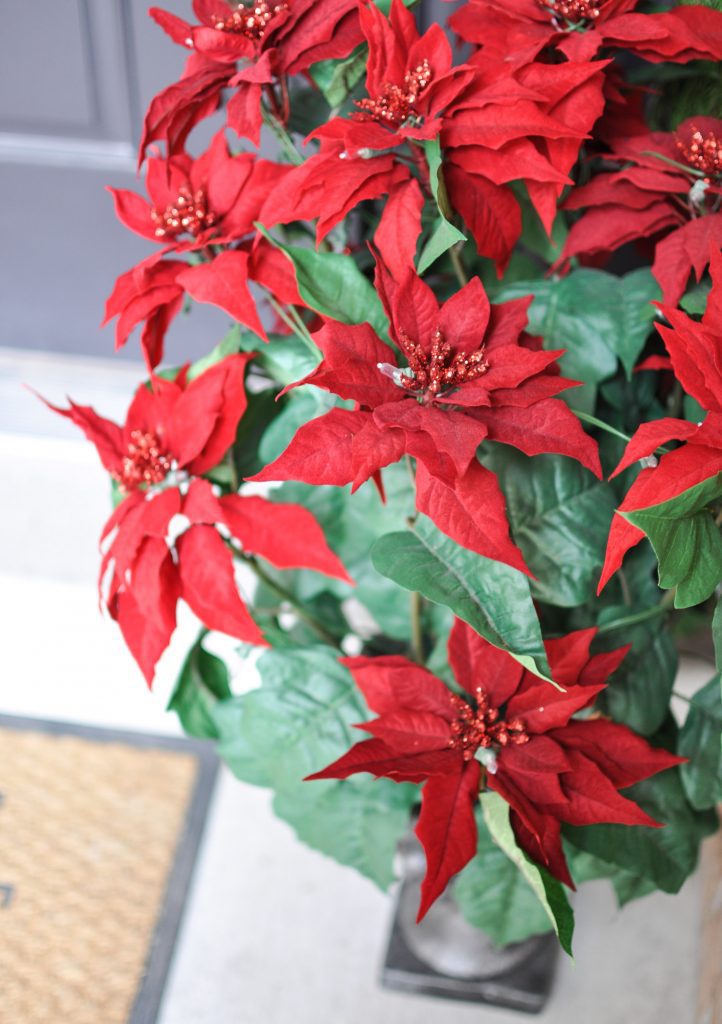 Looking for simple Porch Decorating Ideas? Create a classic appeal with these traditional poinsettias and cedar garland for a Classic Christmas Porch.