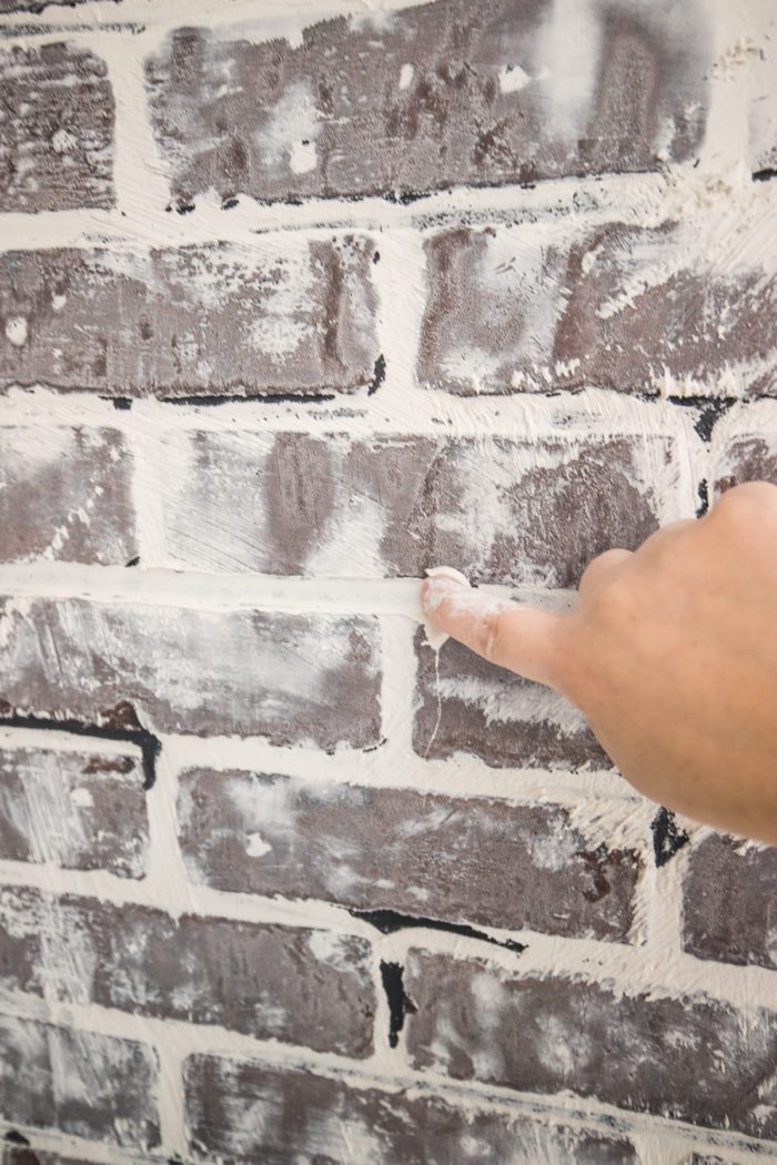 create a faux brick wall using sheetrock compound over brick panels. 