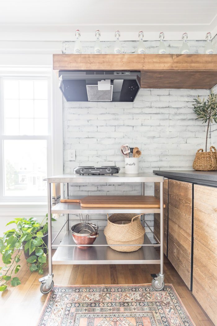 Moveable cart under vent hood for functional kitchenette space. 