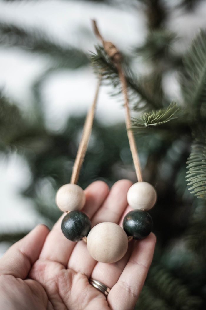 Paint Wooden Beads and thread on leather lacing to create a simple, modern Christmas Ornament.