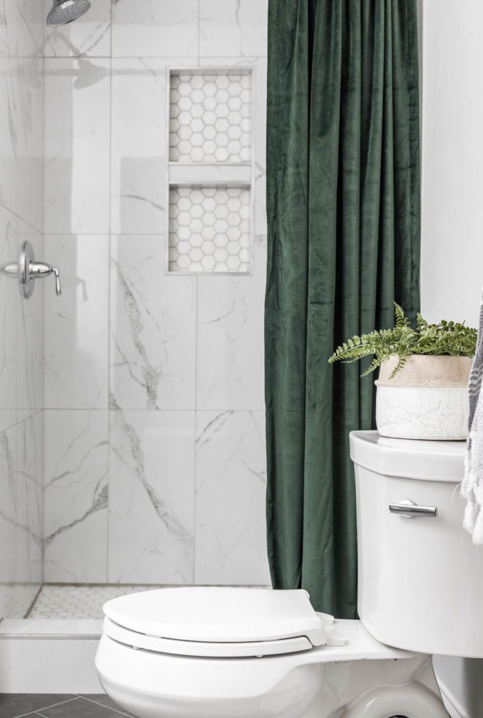 green velvet shower curtain with marble shower tile