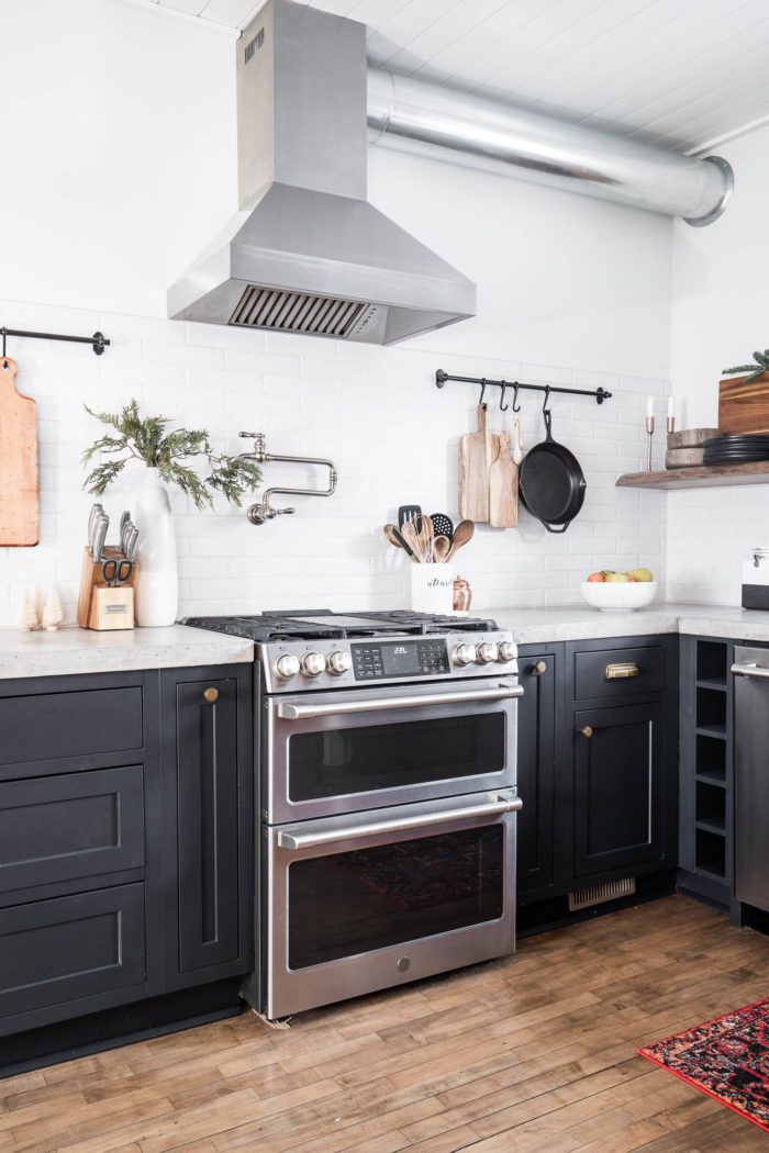 Modern Rustic Christmas Decor in the kitchen with black cabinets, open shelving and tile backsplash. Using just a few clippings from your yard makes all the difference. 