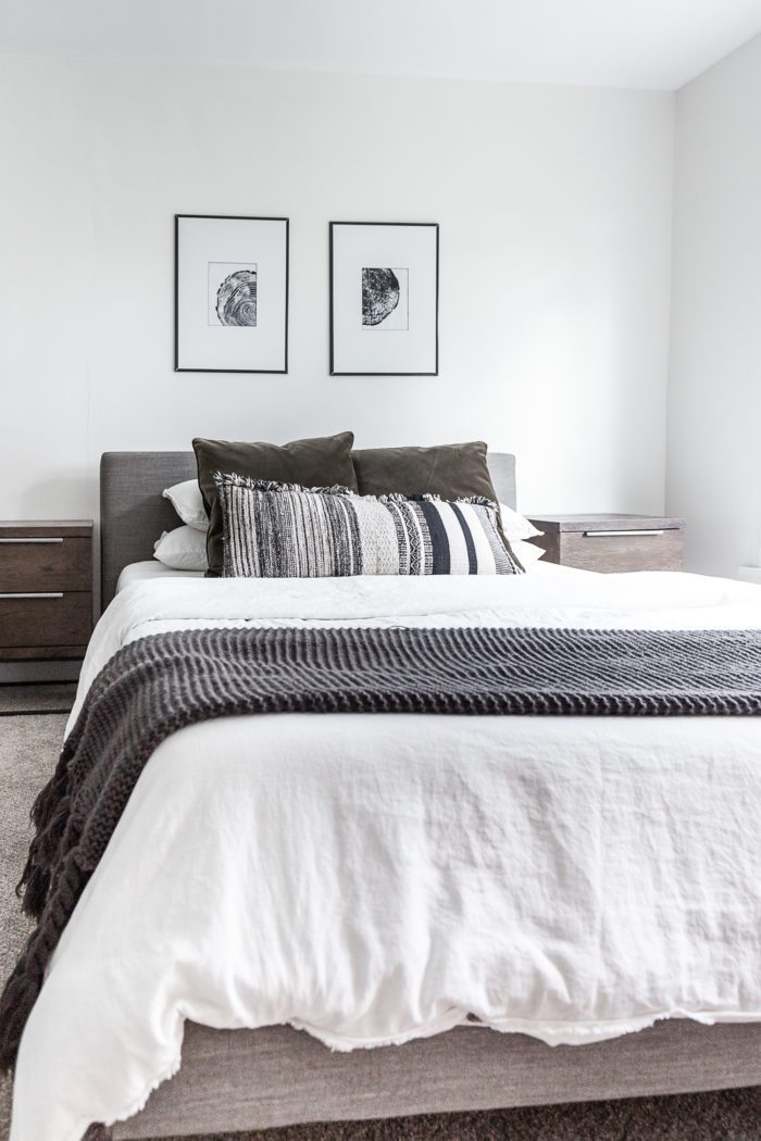 White bedding in the master bedroom with contrasting accents. 