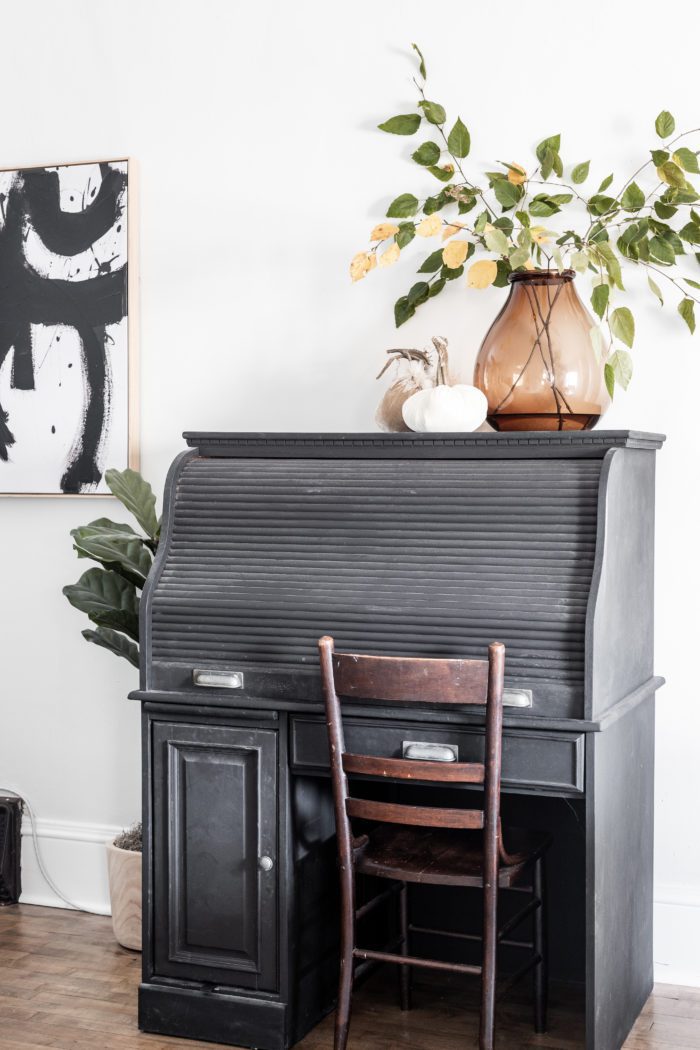 Black roll top desk with neutral fall decor. 
