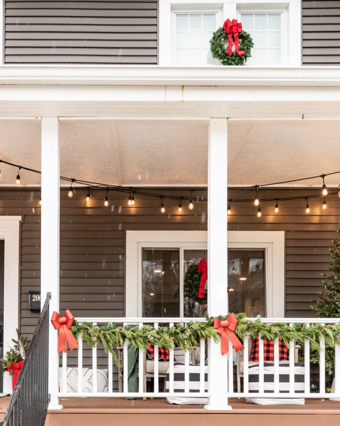 Classic Christmas Porch Decor, Garland with Red Bows on Porch Railing. 