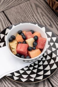 Fresh tropical fruit in white bowl served as part of a fun summer table setting.