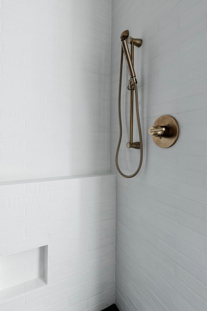 Master Shower Ideas - Champagne bronze fixtures with black and white tile. 