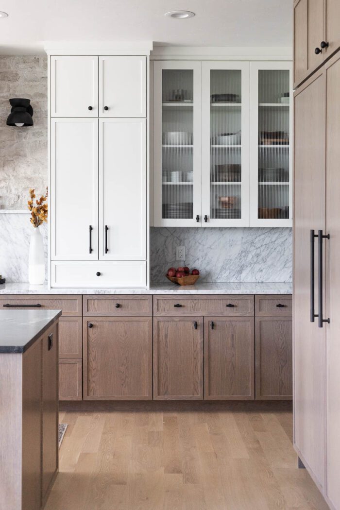 Two toned cabinets - White Uppers, white oak lowers with reeded glass doors styled for Fall. 