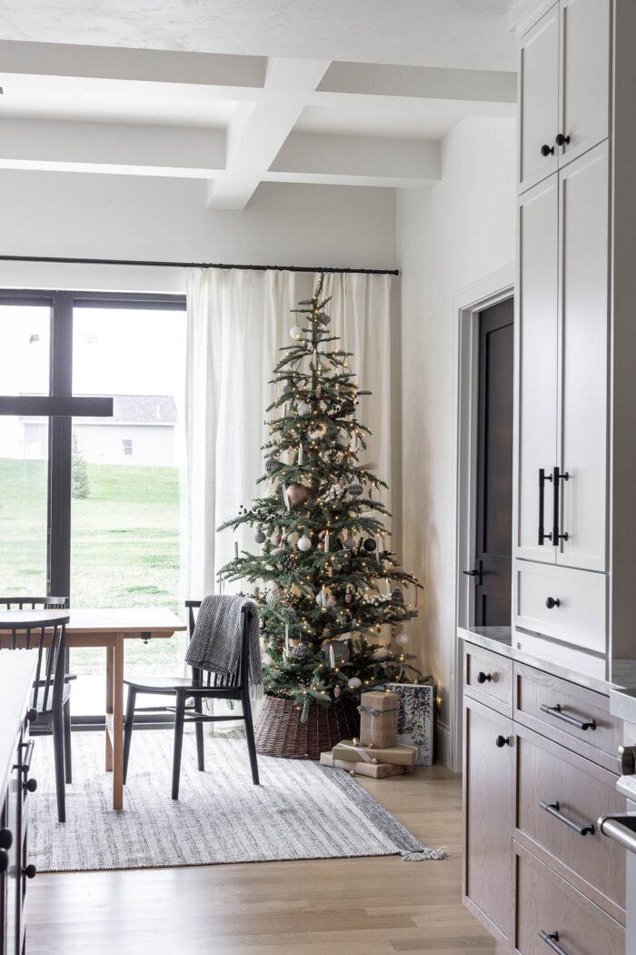 Neutral, Minimalist Modern Christmas Tree in the Dining room with rattan tree collar. 